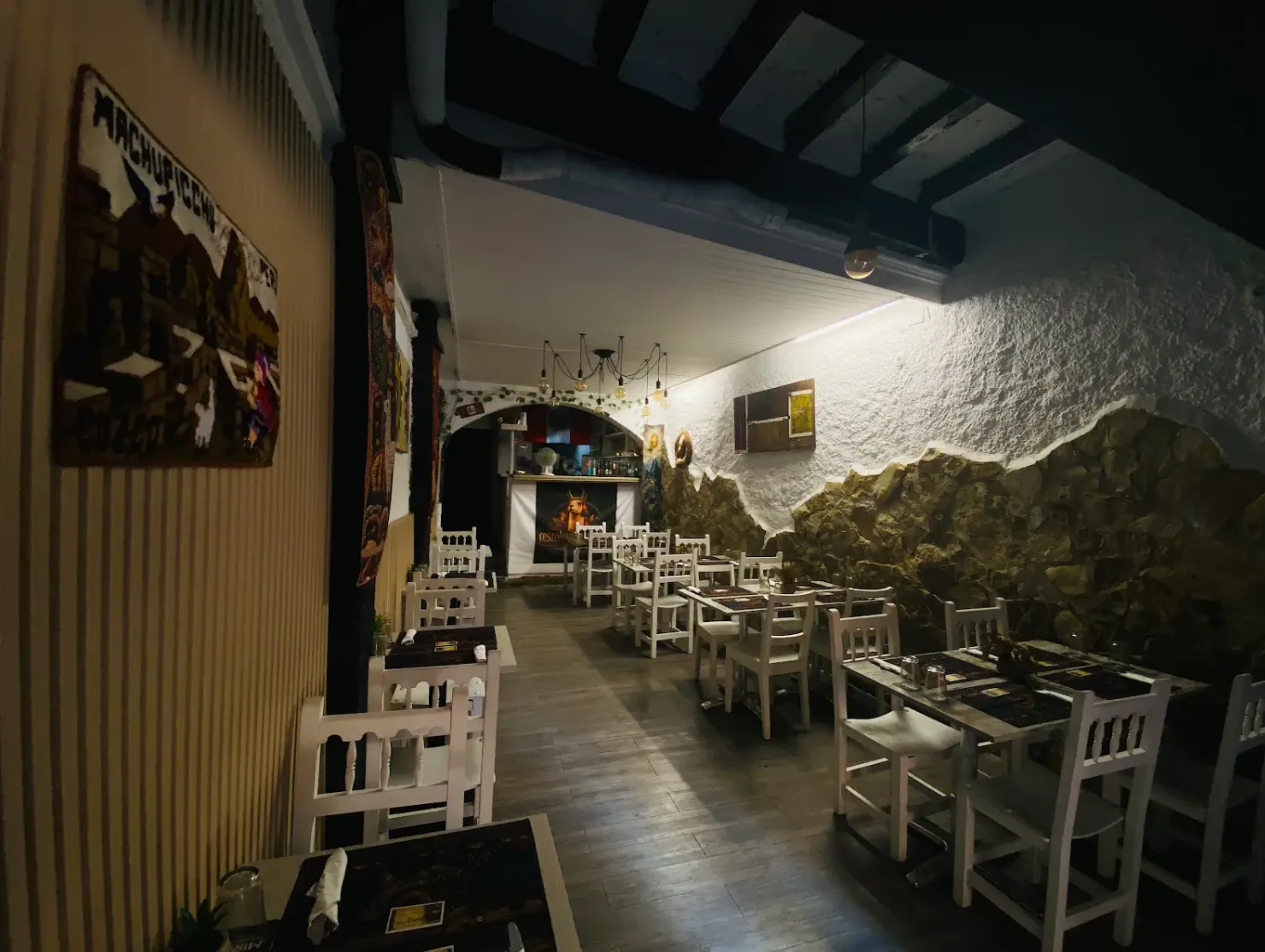 Salón de Restobar Marquina's con iluminación cálida y vigas de madera