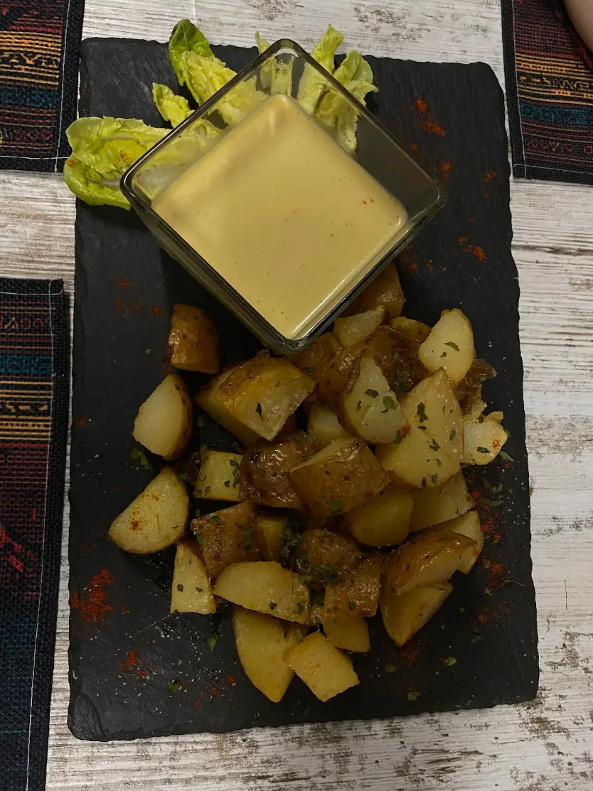 Patatas rústicas con salsa de la casa en Marquina's